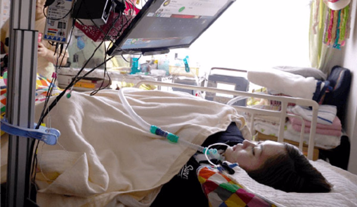 fotonoticia_20181211154445-1812612969_1200 Persona con discapacidad fisica y movilidad reducida en una camilla con controlador ocular manejando los robots